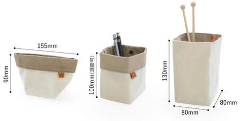 three different sizes of white fabric pouches or baskets, each containing various items such as pens and knitting needles.