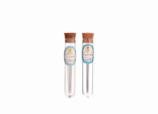 Two glass tubes with metal needles, each labeled with Japanese text.