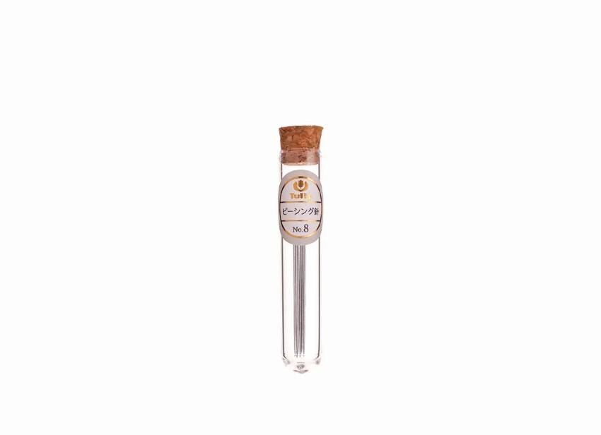 A clear glass tube with a cork stopper containing a metal object, possibly a pencil or pen, against a white background.