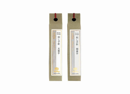 Two identical beige boxes with red handles, each containing a small label with Japanese text and a logo.