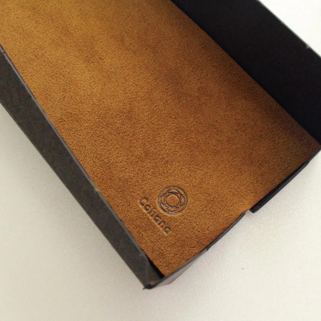 a close-up view of a brown leather surface with a circular logo imprinted on it.