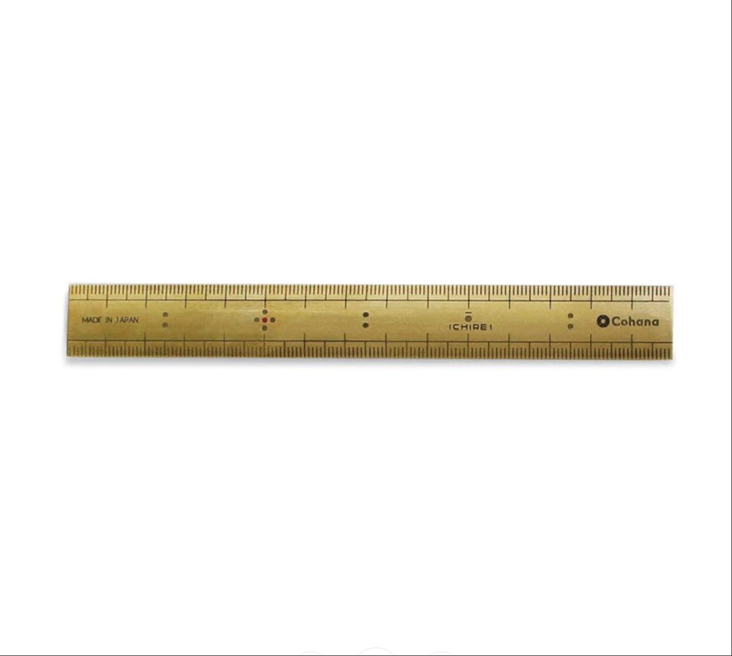 A gold-colored ruler with black markings and text, including the brand name "Cohana".