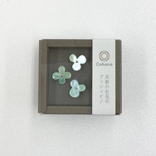A small square box containing three green flower-shaped objects, with a label on the side that reads "Cohana" and Japanese text below it.
