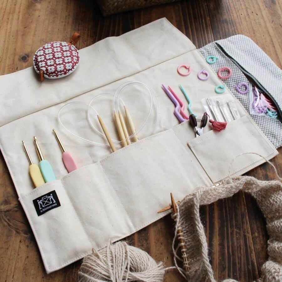 A beige sewing kit with various crochet and knitting tools, including crochet hooks, knitting needles, and yarn, neatly organized and ready for use.