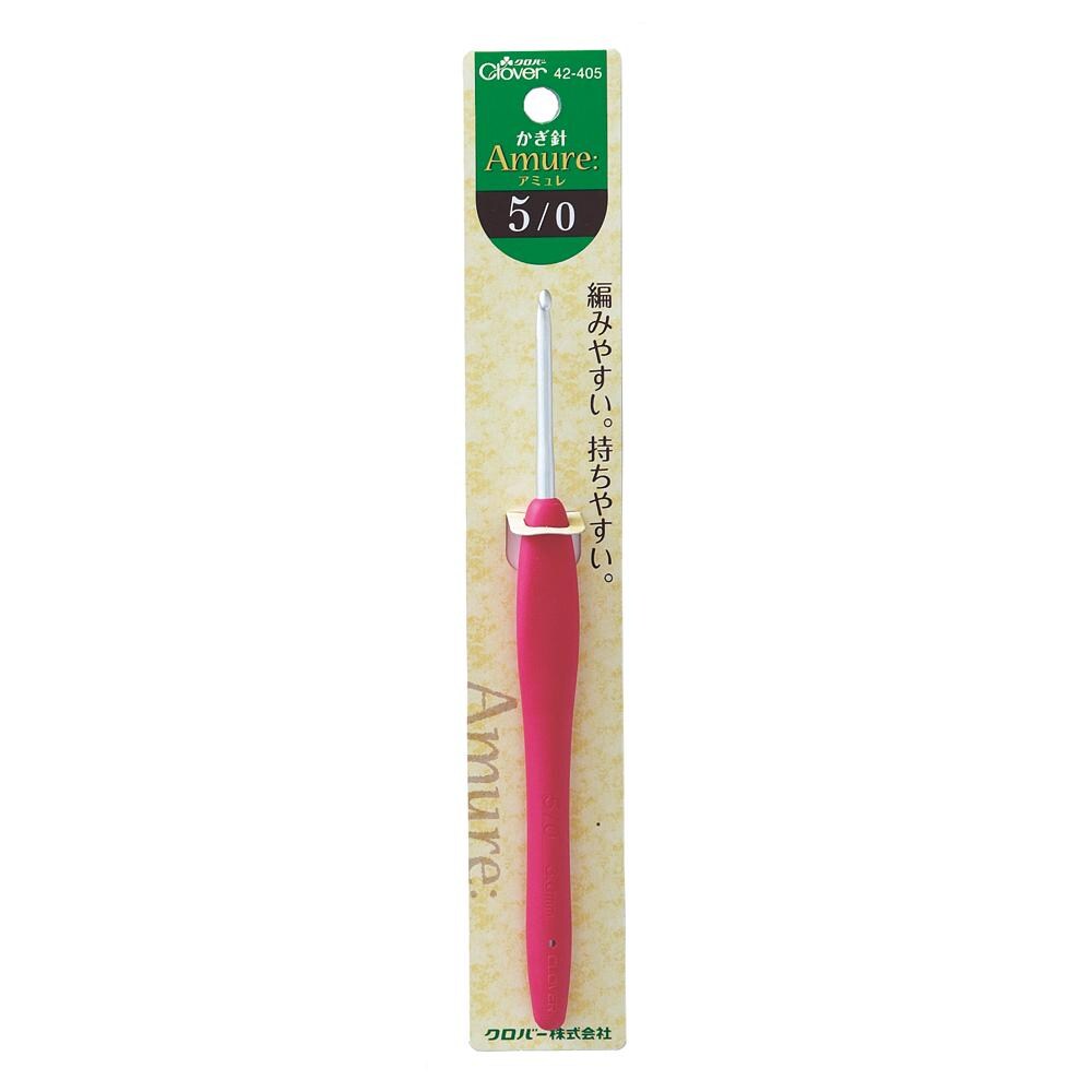 A pink crochet hook with a green and white label on a yellow background.