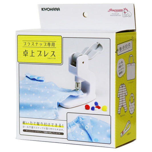 The image is a box containing a sewing machine and various sewing tools, including a blue polka dot fabric and some buttons.