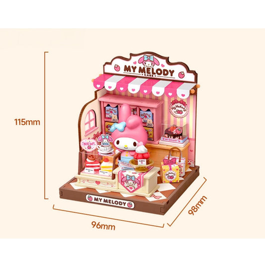 A pink and white My Melody dollhouse with various My Melody-themed items, including a pink My Melody doll, a pink My Melody sign, and a pink My Melody cake. The dollhouse is set up in a miniature shop-like environment, complete with a pink awning and other decorative elements. The image is approximately 115mm in width and 96mm in height.