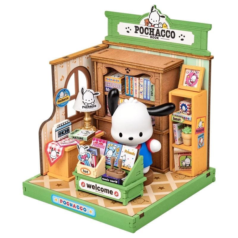 A miniature toy store called Pochacoo Book, featuring a small white dog figurine in the center, surrounded by various toys and books.