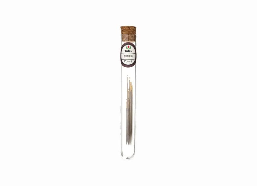 A clear glass tube containing a small amount of what appears to be a metallic substance, possibly a type of metal wire or rod.