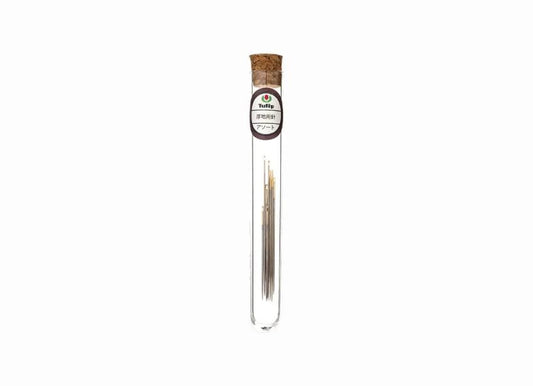A clear glass tube containing a small amount of what appears to be a metallic substance, possibly a type of metal wire or rod.