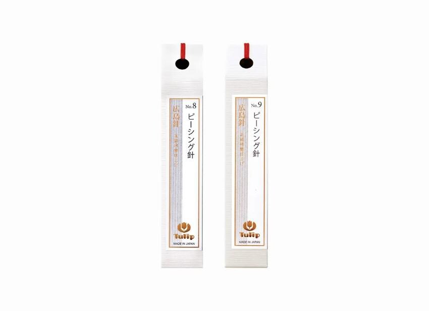 two identical white pencil holders with red and gold accents, each featuring Japanese text and a logo.