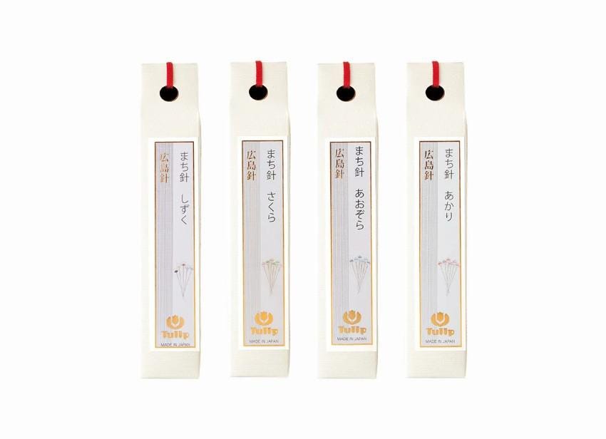 four identical white boxes with red handles, each containing a small yellow umbrella.