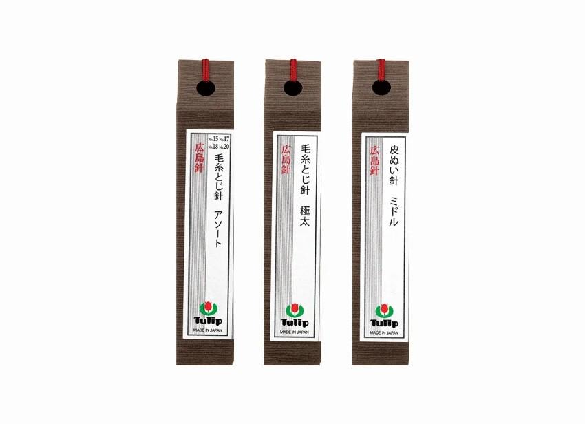 Three brown labels with red strings, each containing Japanese text and a logo, arranged in a row.