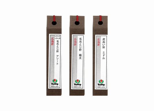 Three brown labels with red strings, each containing Japanese text and a logo, arranged in a row.