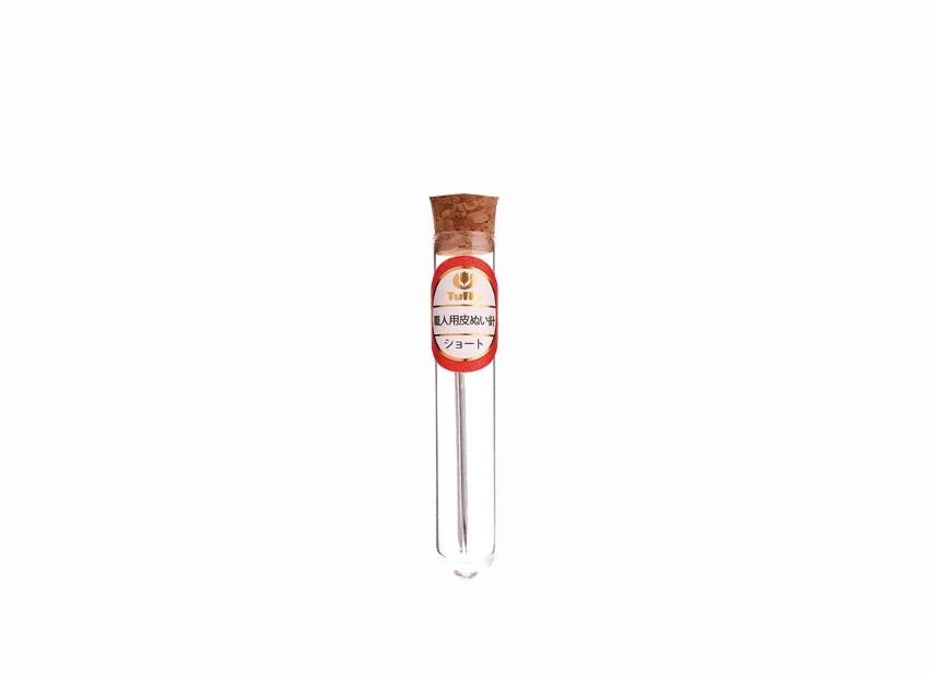 A clear glass tube with a cork stopper and a red label with white text.