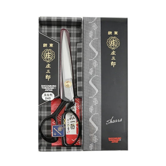 A pair of Japanese scissors with a black and white checkered box and a black and white patterned sleeve.