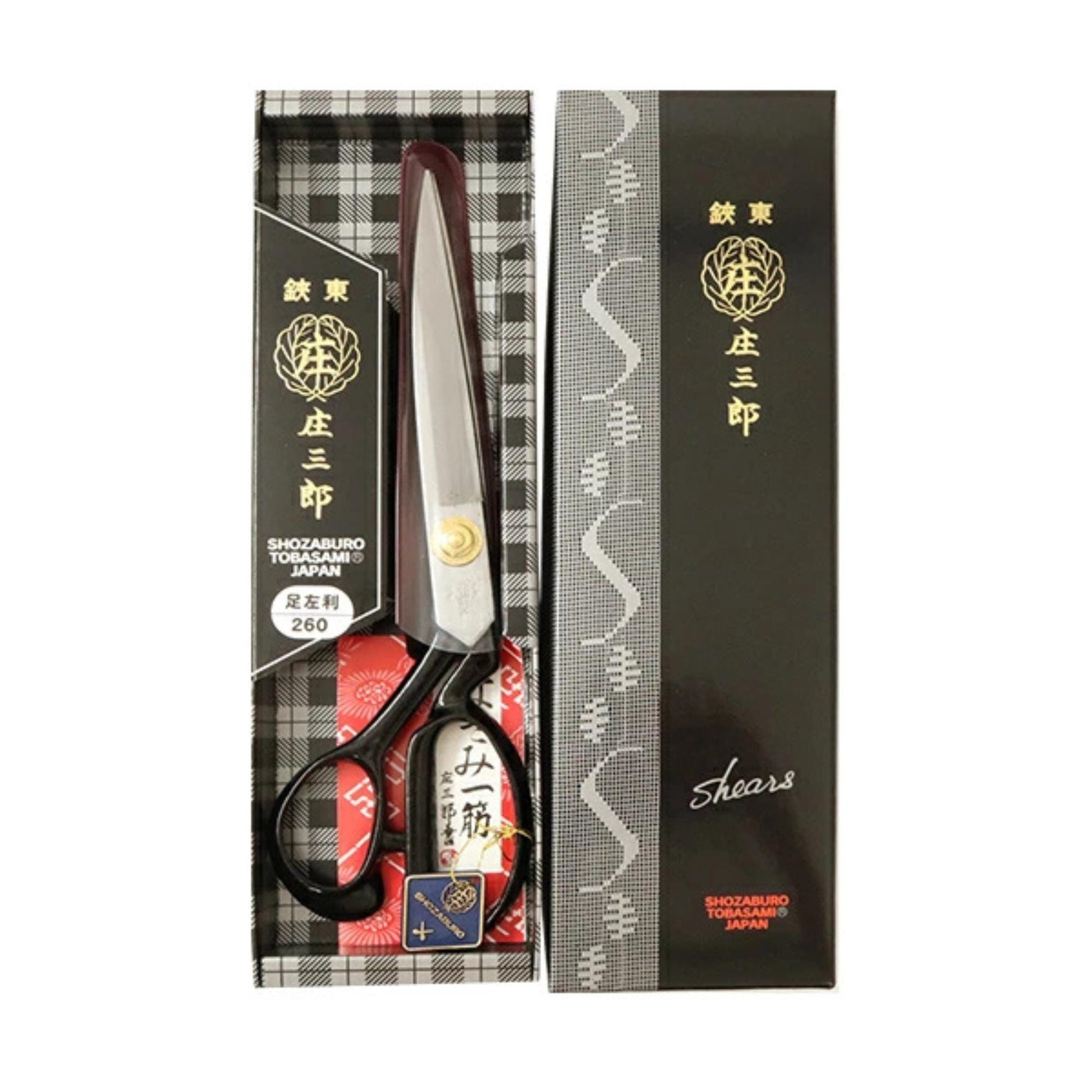 A pair of Japanese shears with a black and white checkered box and a black and white patterned sleeve.