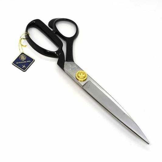 A pair of black and silver scissors with gold accents, resting on a white background.