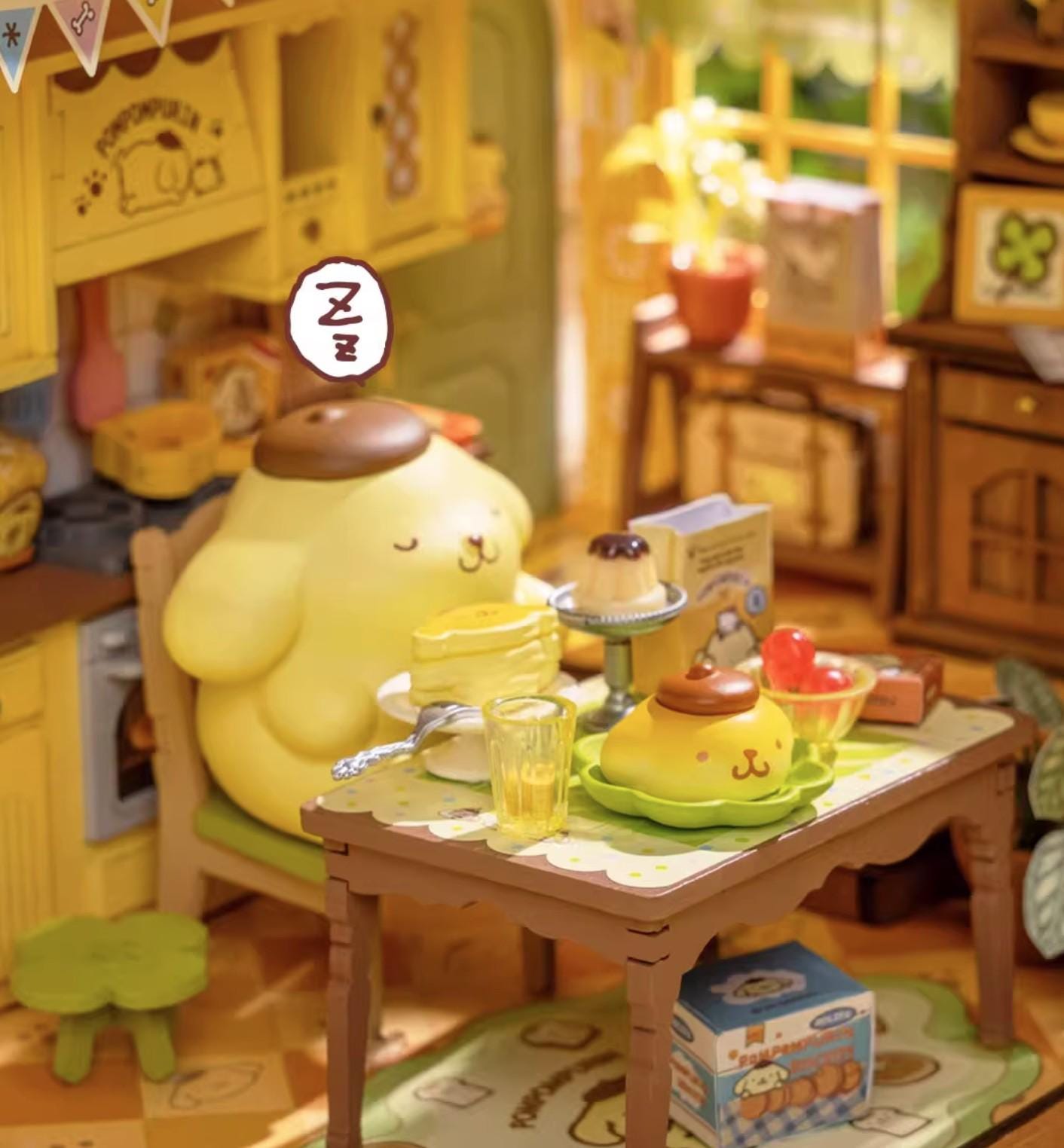 A yellow toy figurine is sitting at a table with various food items, including a cup, a bowl, and a cake, in a kitchen setting.