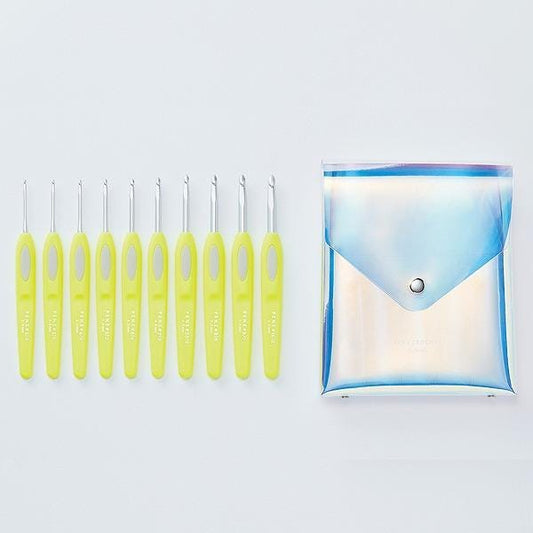 A set of yellow crochet hooks and a clear plastic bag with a silver button, both placed on a white background.