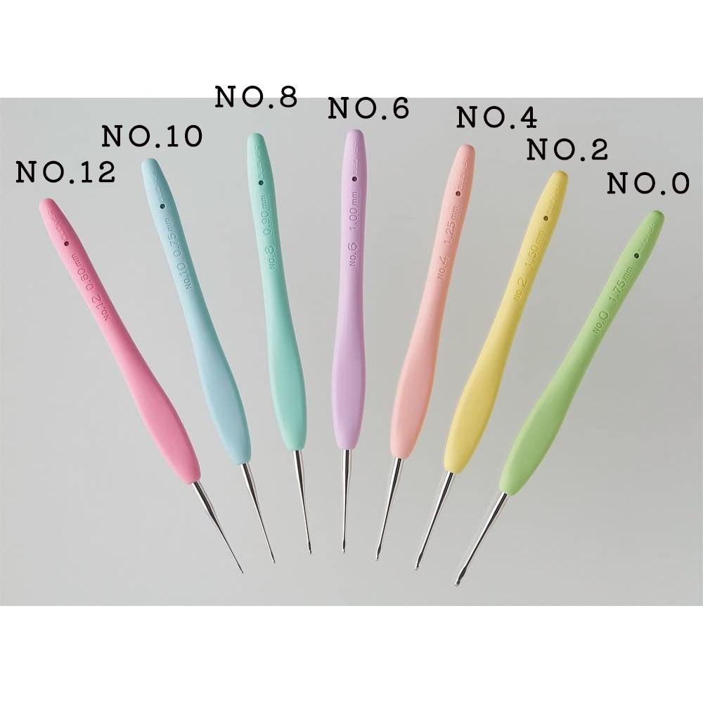 A collection of crochet hooks in various colors, including pink, blue, green, yellow, and purple, arranged in a row.