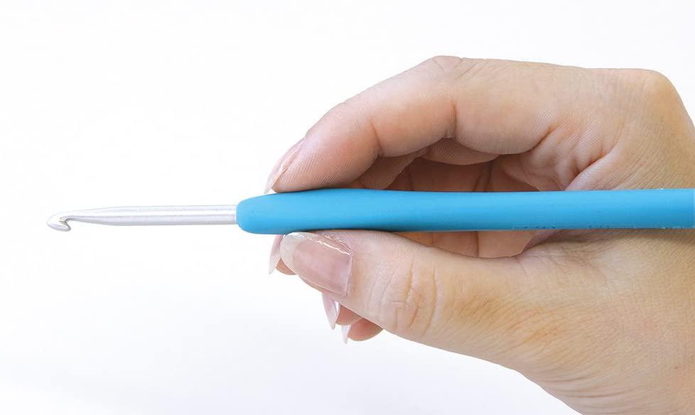 A hand holding a blue crochet hook, ready to crochet.
