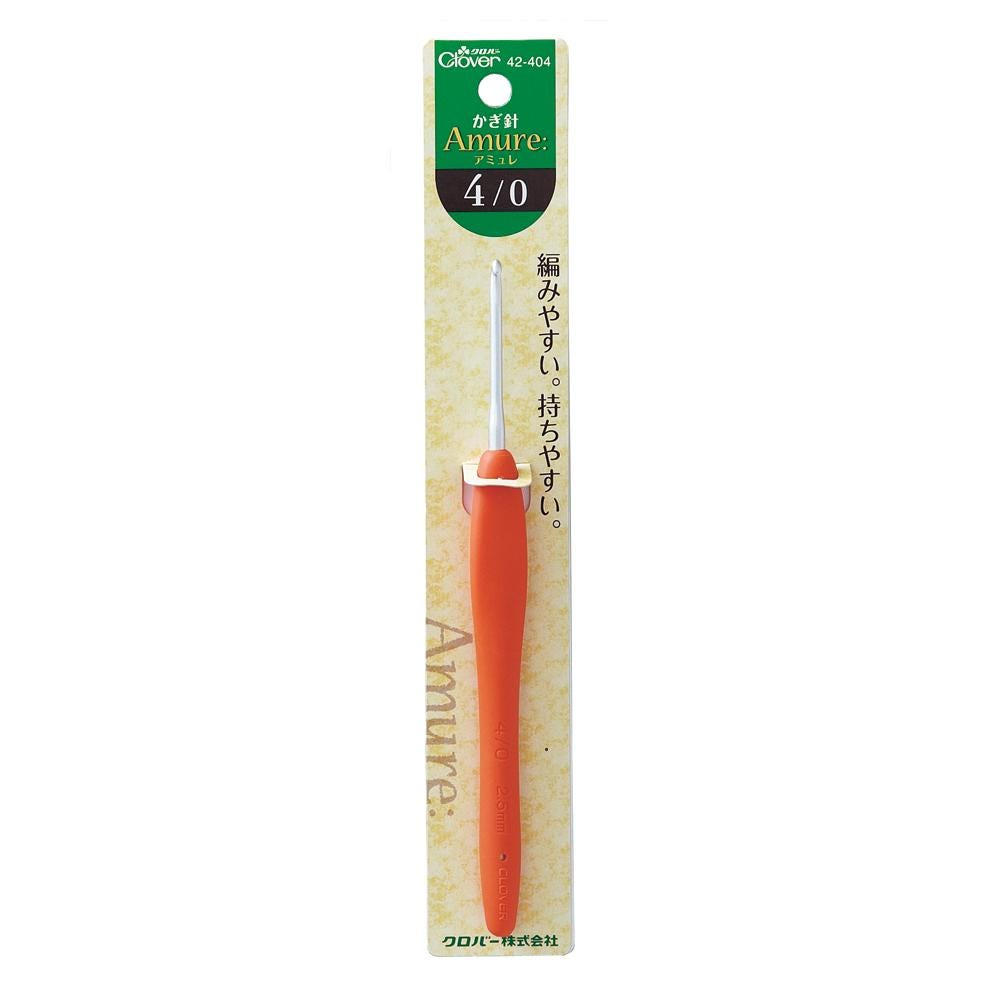 a crochet hook with a bright orange handle, which is part of a product packaging.
