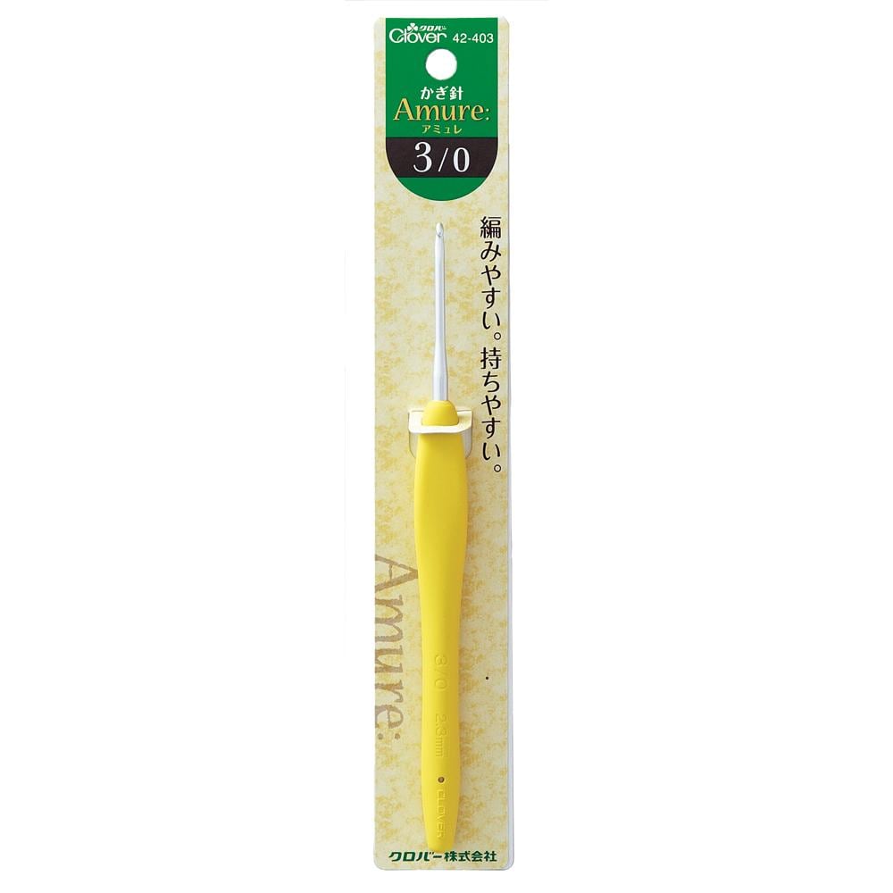 A yellow crochet hook with a green and white label on a package.
