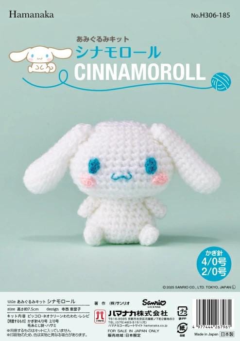 a crocheted stuffed animal resembling a white bunny with blue eyes and a pink nose, sitting on a light blue background.