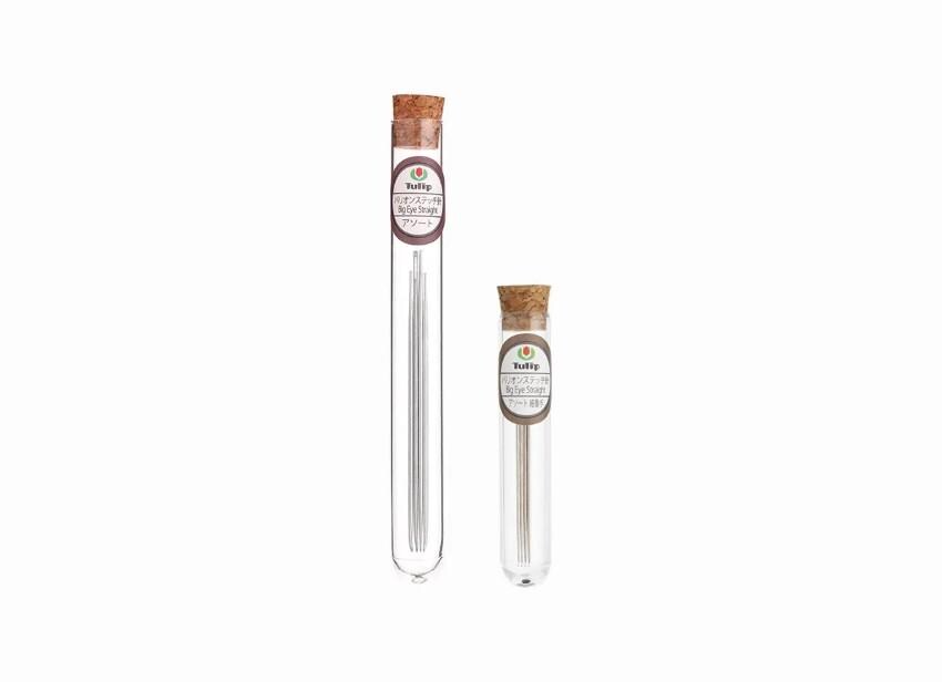 Two glass tubes with cork stoppers, each containing a small metal object, are shown against a white background.