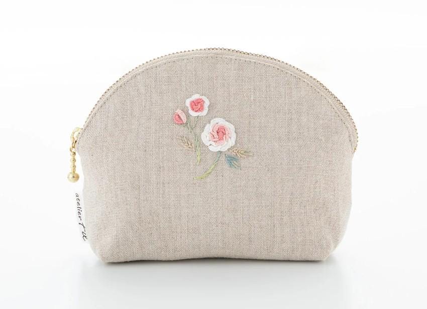 A beige cosmetic bag with a floral embroidered design on the front.