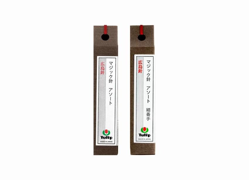 two identical brown boxes with red handles, each containing Japanese text and a logo.