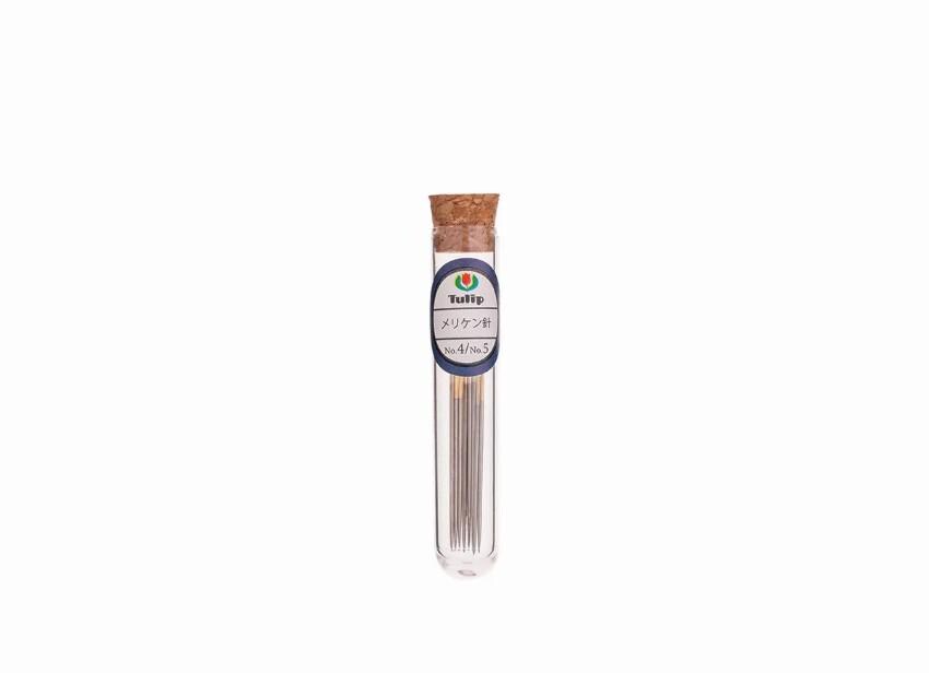 A clear glass tube containing a collection of metal needles, with a cork stopper at the top.
