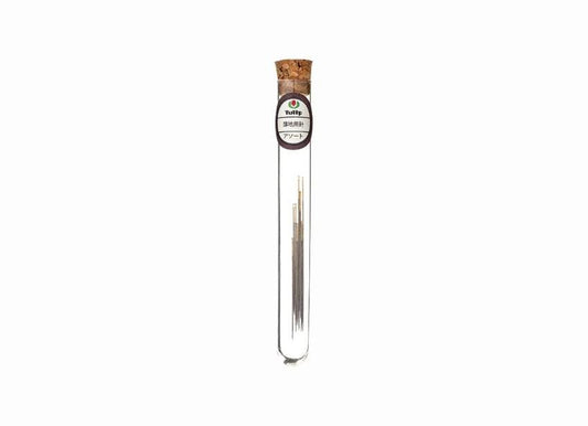 A clear glass tube containing a small amount of what appears to be a liquid or solid substance, with a cork stopper at the top.