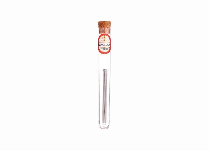 A clear glass tube containing a silver object, with a red and white label on the tube.