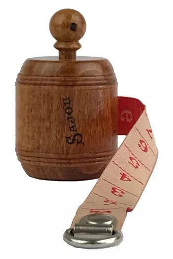 A wooden barrel with a red measuring tape attached to it.