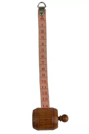A wooden barrel with a red measuring tape attached to it, displaying numbers from 1 to 14.