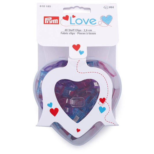 A package of Prym Love fabric clips, which are 40 clippings in size, 2.6 cm in length, and 2.2 cm in width. The package is designed to resemble a heart shape, with the Prym logo prominently displayed.