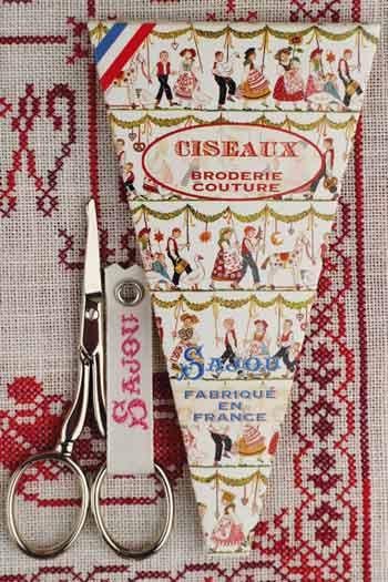 a pair of scissors and a vintage-style sewing kit with a French label.