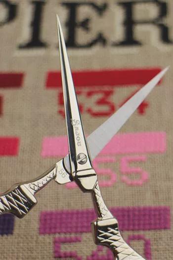A pair of silver scissors with the brand name "Pierrot" on the blades is shown in the foreground, with a colorful background featuring the word "Pierrot" in a stylized font.