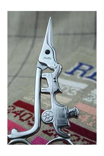 A close-up image of a pair of scissors with a unique, ornate design on the handle.