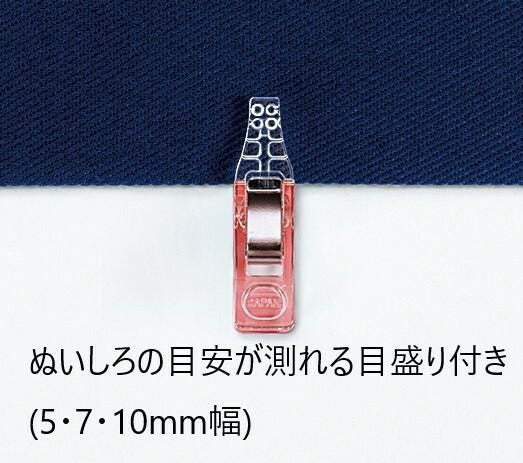 A red and silver metal clip is attached to a blue fabric, with text below the image providing information about the clip's size.