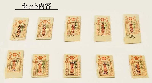 nine identical beige paper items with red and black Japanese characters and designs, arranged in a grid pattern.
