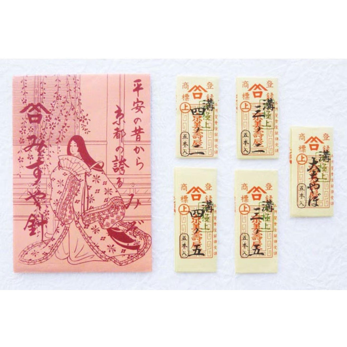 a pink paper with Japanese text and an illustration of a woman, as well as four identical cards with similar Japanese text and illustrations.