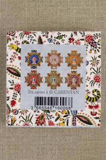 a square-shaped object with a floral pattern and six distinct badges or insignia on it.