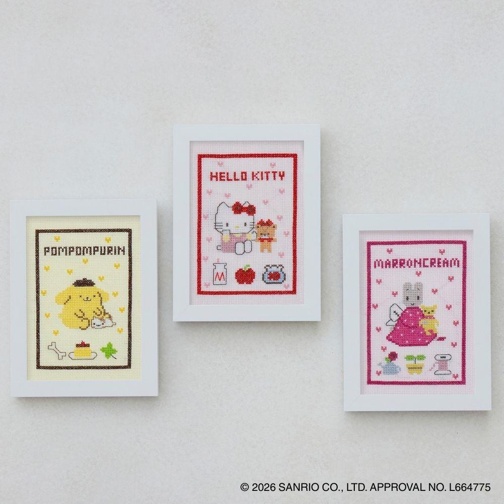 three framed cross-stitch designs featuring characters from the Hello Kitty franchise.