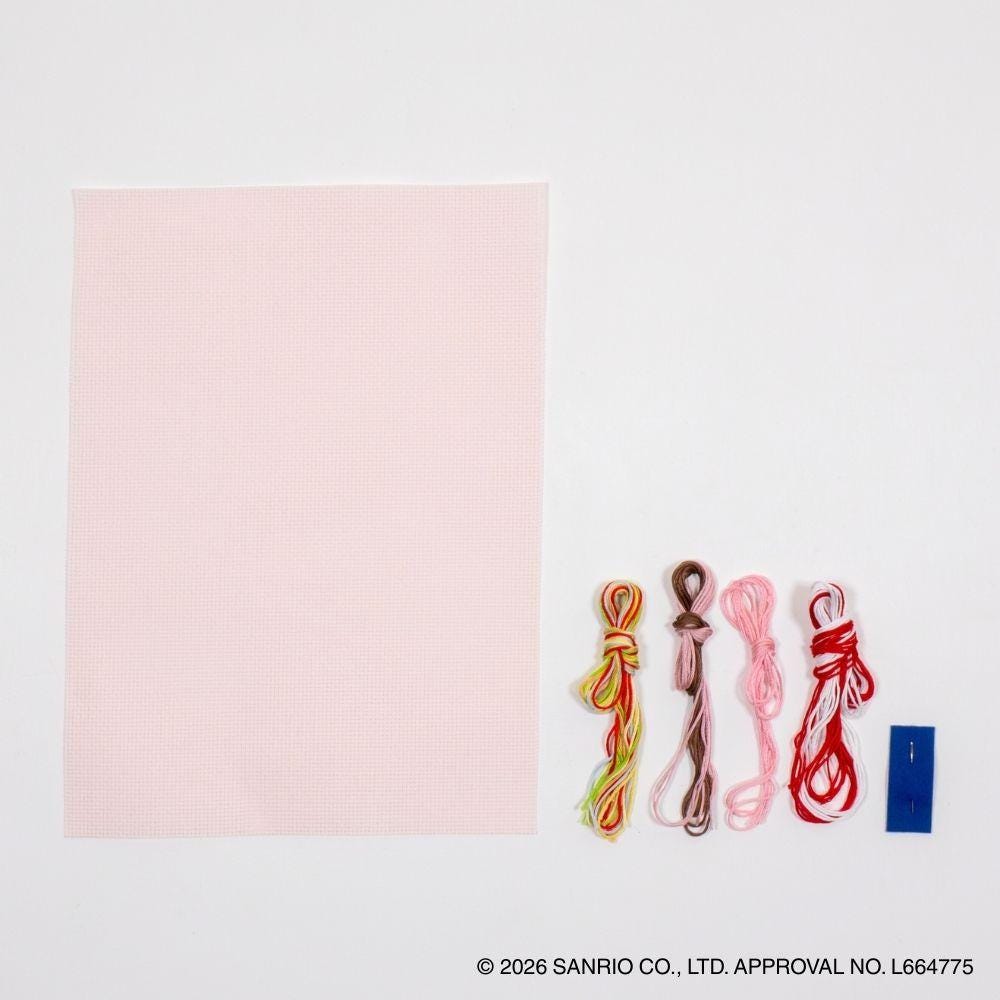 a pink square and six different colored embroidery floss strings arranged next to it.