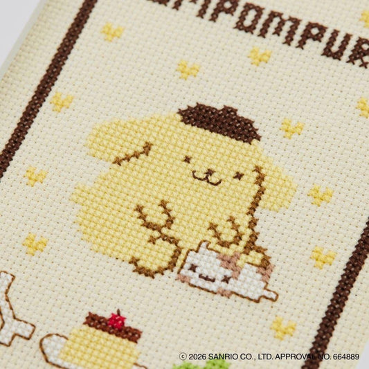 The image is a close-up of a cross-stitch pattern featuring a cute yellow character, likely a character from the Sanrio series. The character is surrounded by small yellow hearts, and the background is a light beige color. The text "SANRIO CO. LTD. APPROVED BY 66489" is visible, indicating that the image is a product of Sanrio Co., Ltd.