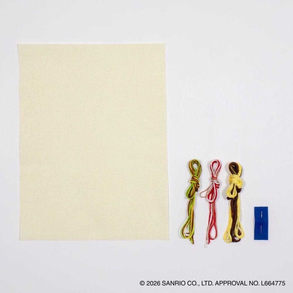 a blank piece of paper, three spools of thread in different colors (yellow, green, and brown), and a blue pushpin on a white background.