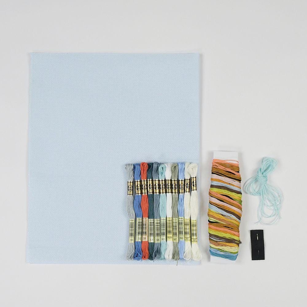 a collection of embroidery floss and a piece of paper, likely for a sewing or crafting project.